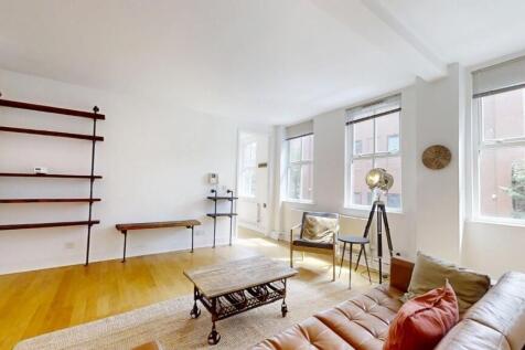 Bright and airy living room featuring large win...