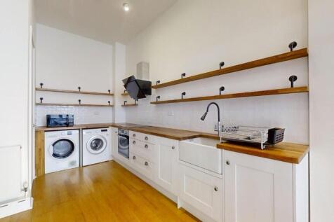 Bright and modern kitchen featuring white cabin...