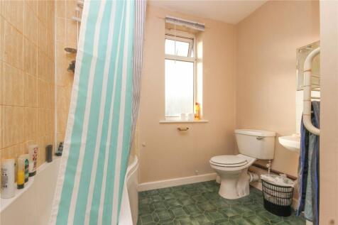 Bright and clean bathroom featuring a bathtub w...