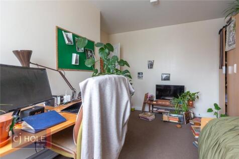 A cozy and well-organized single bedroom featur...