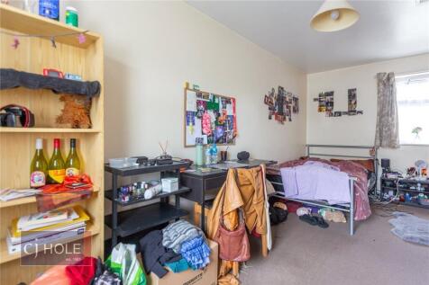 A cozy single bedroom featuring a comfortable b...