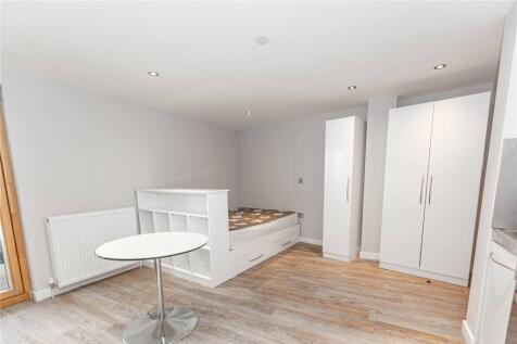 A bright and tidy single bedroom featuring a be...