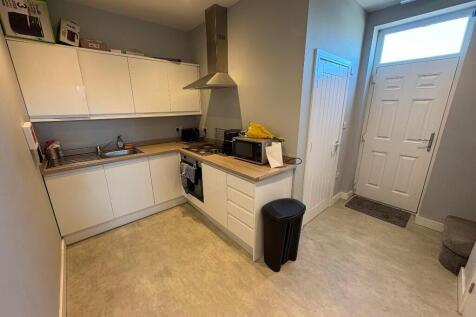 A neat and modern kitchen featuring white cabin...