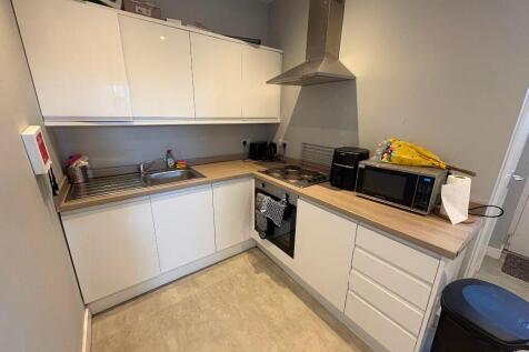 A modern kitchen featuring ample white cabinetr...