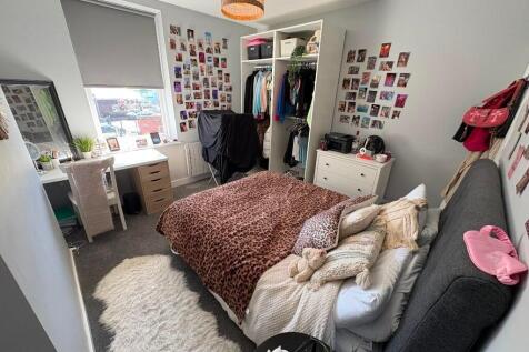 Cozy single bedroom featuring a comfortable bed...