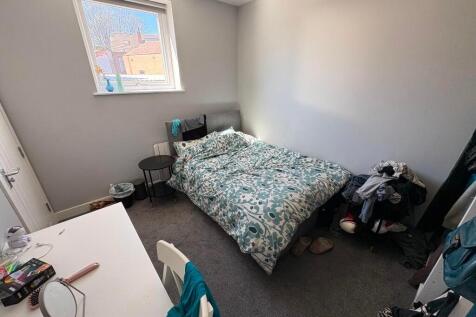 A cozy single bedroom featuring a comfortable b...