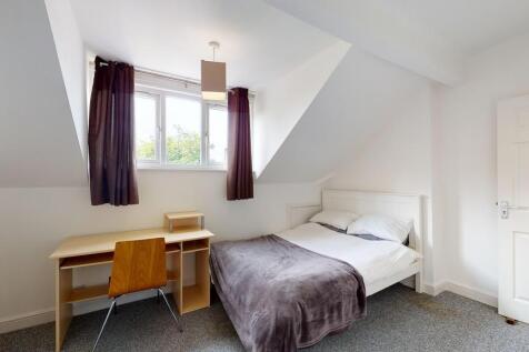 A cozy and well-lit single bedroom featuring a ...