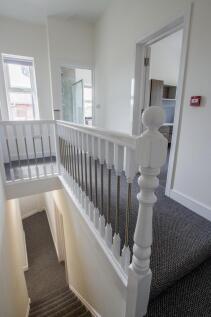 Bright and clean hallway with neutral decor fea...