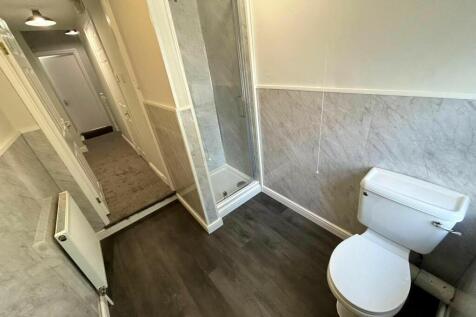 Bright and tidy bathroom featuring a clean toil...