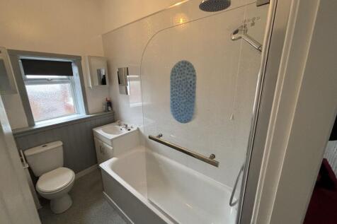 Bright and clean bathroom suite featuring a ful...