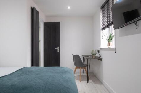 A spacious and well-lit double bedroom featurin...