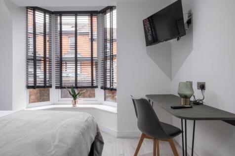 A bright and modern double bedroom with stylish...