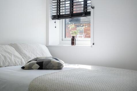 A cozy double bedroom featuring a stylish desig...