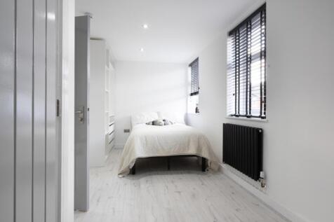 A stylish double bedroom featuring ample natura...