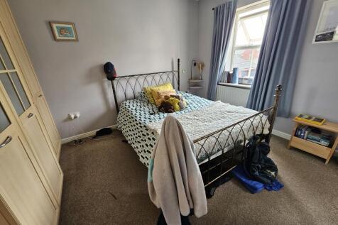 A cozy double bedroom featuring a metal framed ...