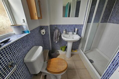A modern bathroom featuring a tiled shower encl...