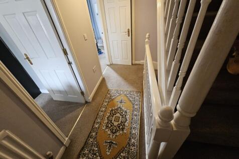 A neat and welcoming hallway featuring a patter...
