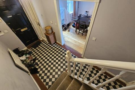 Bright and tidy hallway with patterned floor ti...