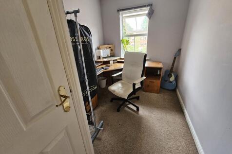 Cozy single bedroom featuring a comfortable des...