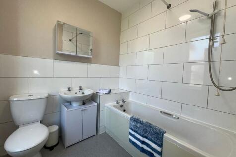A bright and clean bathroom suite featuring a w...