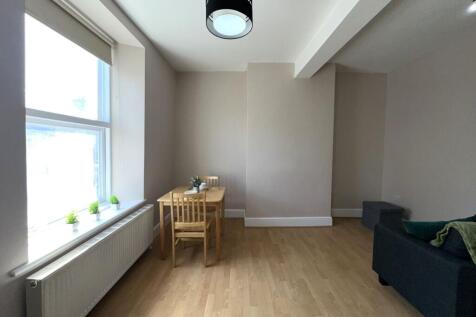 A bright and tidy living room featuring light w...