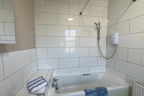 Bright and clean bathroom suite featuring a mod...