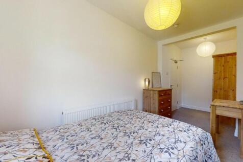 Bright and cozy master bedroom featuring a comf...