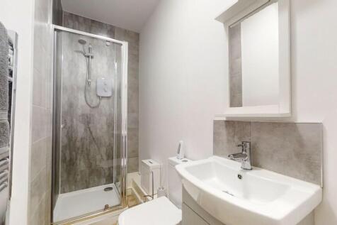 A modern bathroom featuring a sleek walk-in sho...