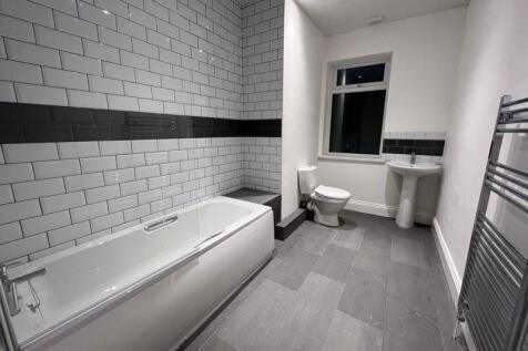A modern and spacious bathroom featuring a full...