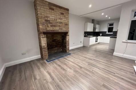 A modern open-plan living room with clean, ligh...