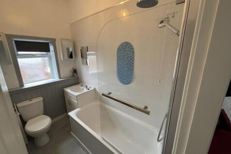 Bright and clean bathroom suite featuring a bat...
