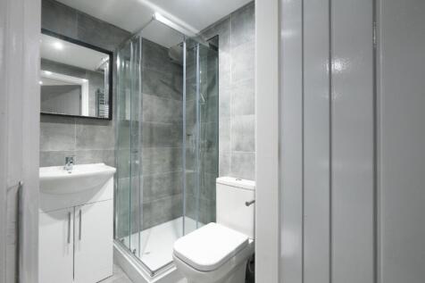 This modern bathroom features sleek tiles and a...