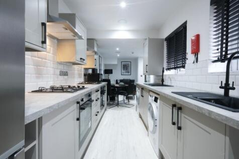 A modern kitchen featuring sleek cabinetry, amp...