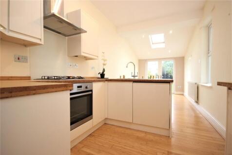 Bright, modern kitchen with clean white cabinet...
