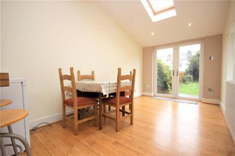 Bright and tidy dining area adjacent to a kitch...