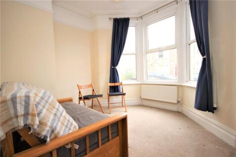 A simple, bright room with a large bay window f...