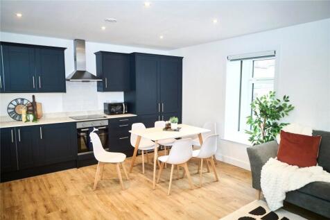 A modern kitchen with sleek black cabinetry and...
