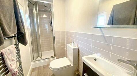 A clean and modern bathroom featuring a shower,...