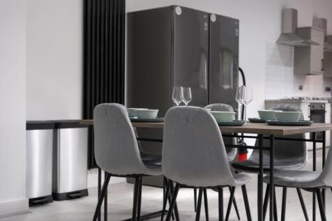Modern kitchen featuring a sleek dining area wi...