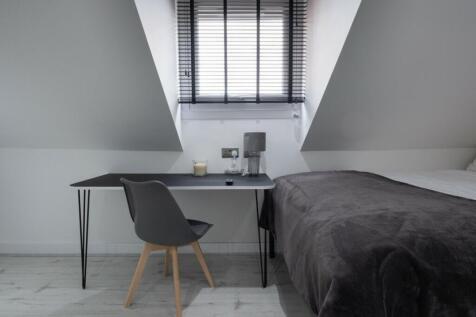 This cozy double bedroom features a stylish des...