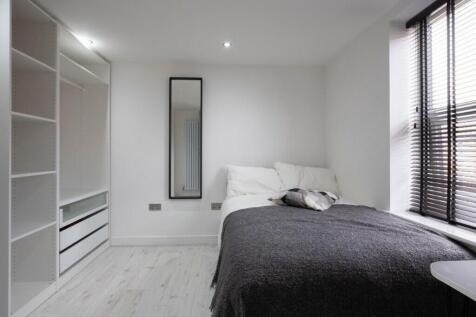 This inviting double bedroom features a comfort...