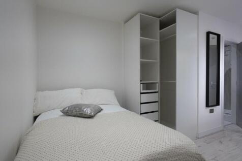 This inviting double bedroom features a cozy at...