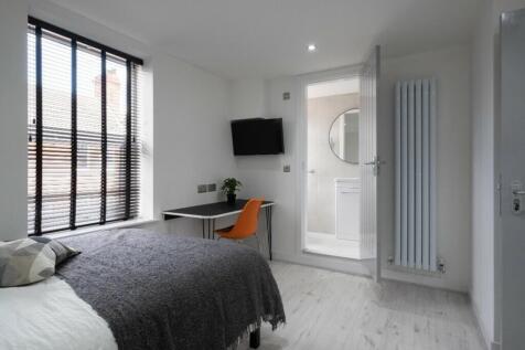 This modern double bedroom features large windo...