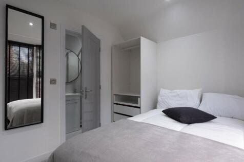 This inviting double bedroom features a comfort...