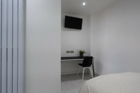This inviting double bedroom features a cozy la...