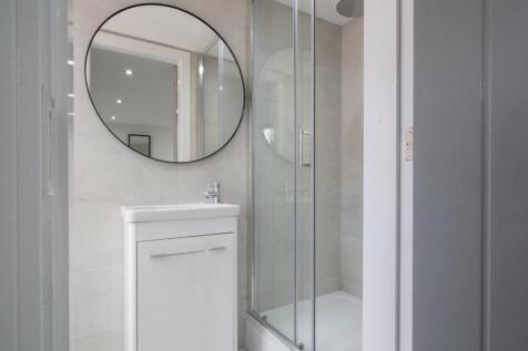 A modern bathroom featuring a sleek shower encl...