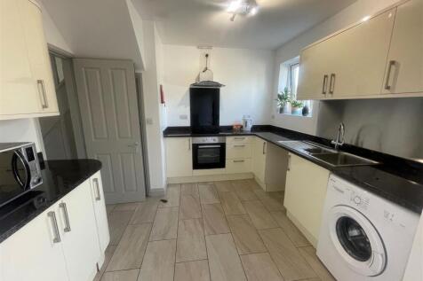 A clean and modern kitchen featuring white cabi...