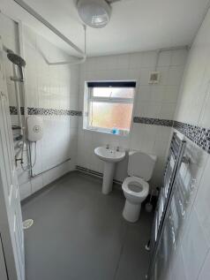 A spacious and bright bathroom featuring a walk...