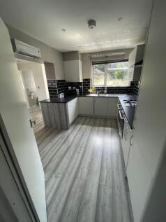 Bright and modern kitchen featuring sleek white...