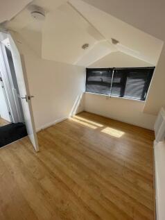 A clean and bright single bedroom with wood lam...